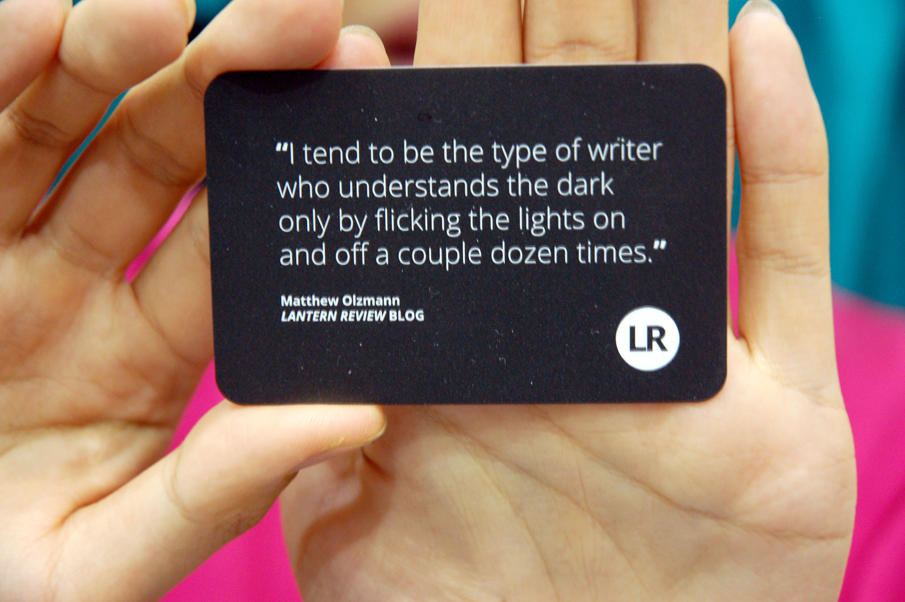 Poet, activist, and performer Wo Chan shows off a quote from Matthew Olzmann about seeking light in darkness.