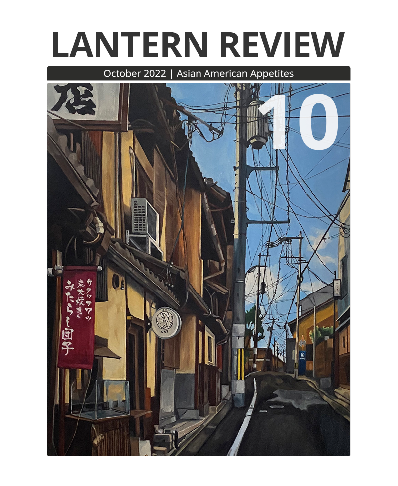 Cover of LANTERN REVIEW Issue 10, October 2022, titled "Asian American Appetites." Beneath the journal's title is a detail from Katherine Akiko Day's painting "Michi." Depicted is a street scene with banners and signs in Japanese lining a narrow, crooked road. The buildings are various shades of warm tan and covered by curved roof tiles. A puddle lies in the middle of the asphalt. The bright-blue sky is veined with criss-crossing electrical wires.